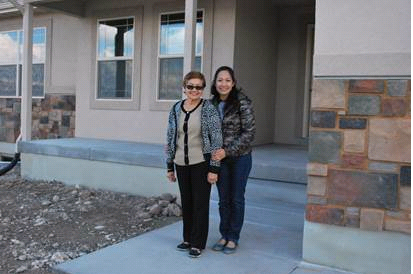 Jane Farr and her daughter in front of her new home.